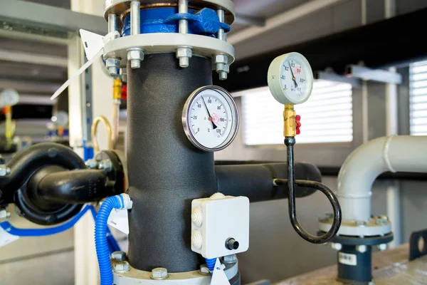 The equipment of the boiler-house, valves, tubes, pressure gauges, thermometer. Close up of manometer, pipe, flow meter, water pumps and valves of heating system in a boiler room.