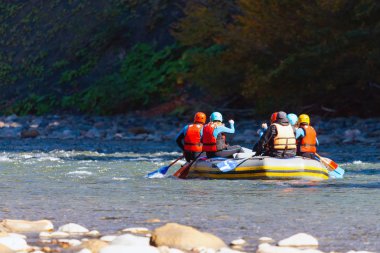 Bir grup genç dağ nehrinde rafting yapıyor..