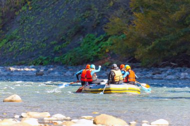 Bir grup genç dağ nehrinde rafting yapıyor..
