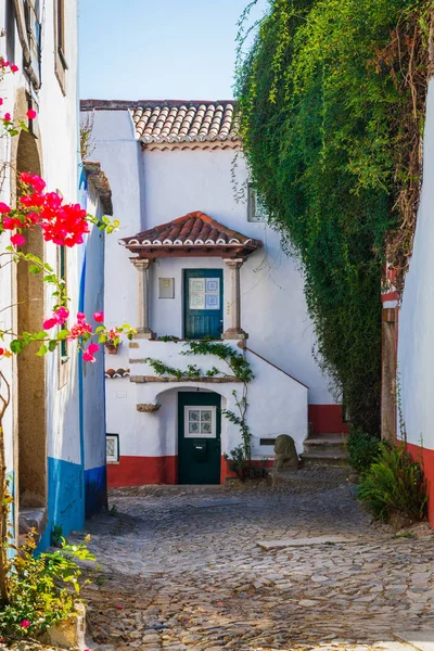 Traditional architecture of old european town. Narrow street of the ancient town. Scenic old town with medieval architecture. Popular tourist destination. White houses and red tiled roofs