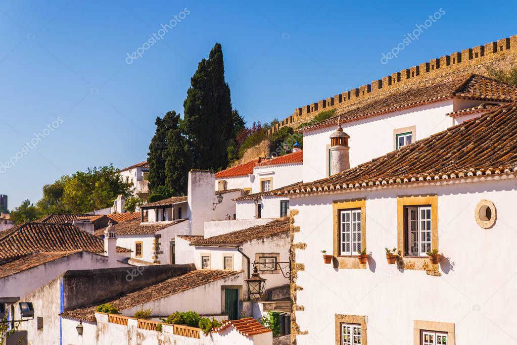 Traditional architecture of old european town. Narrow street of the ancient town. Scenic old town with medieval architecture. Popular tourist destination. White houses and red tiled roofs
