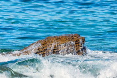 Deniz veya okyanus dalgalarının ve bazı kayaların havadan görünüşü.