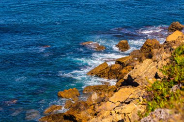 Deniz veya okyanus dalgalarının ve bazı kayaların havadan görünüşü.