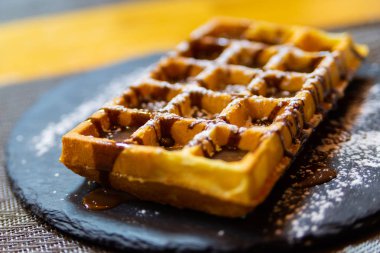 Çikolata soslu ve pudra şekerli Belçika waffle 'ı..