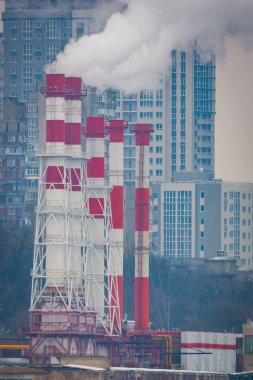Endüstriyel fabrikalardan gelen hava kirliliği. Tüttüren endüstriyel borular. Beyaz pipolu kırmızı