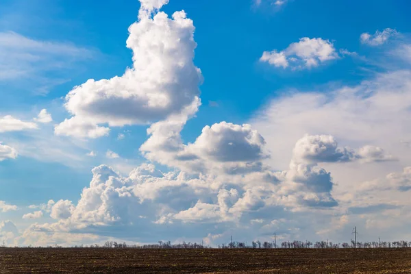 Чорне сільське господарство і блакитне небо з хмарами — стокове фото