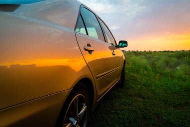 Gün batımında tanımlanamayan lüks bir arabanın arka tarafı.