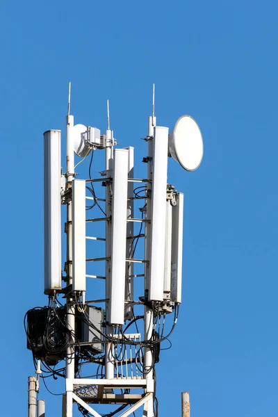 Comunicación Torre del teléfono celular sobre fondo azul del cielo . — Foto de Stock