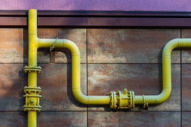 Konut bina duvar önünde sarı gaz borusu