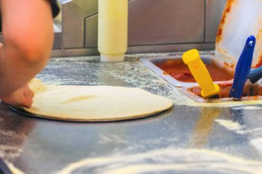 Mutfakta pişirin, malzemeleri pizzanın üzerine koy. Gıda üretimi ve teslimatı.