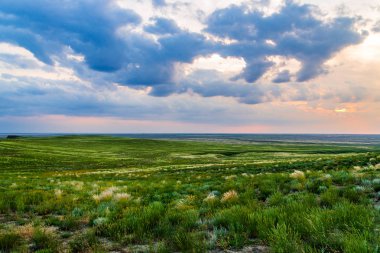 Bozkırda bulutların olduğu manzaralı günbatımı
