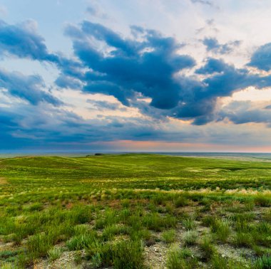 Bozkırda bulutların olduğu manzaralı günbatımı