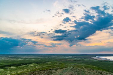 Bozkırda bulutların olduğu manzaralı günbatımı