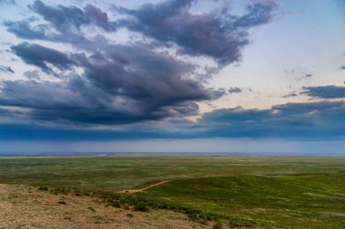 Bozkırda bulutların olduğu manzaralı günbatımı
