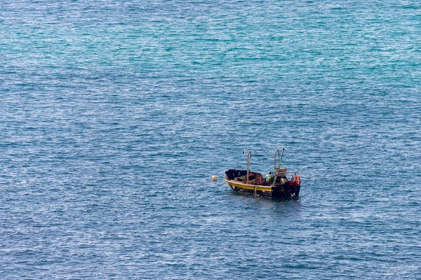 Minimalistic image of the sea with a fishing boat. Blue sea water and clear sky. — Stock Photo, Image