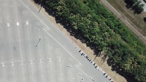 Top nézet autó Parkoló, vasút, sor fák. Légi felvétel a drónautókról, parkolás indul. Autó forgalom és parkolás koncepció — Stock videók