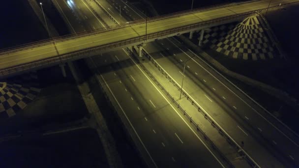 Veduta aerea di un incrocio stradale notturno con una macchina. Vista dal drone dell'autostrada notturna con traffico notturno — Video Stock