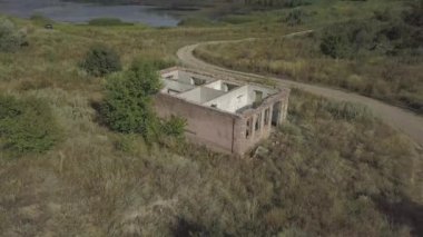 Terk edilmiş ve yol kenarındaki eski tuğla evi yok etmiş. Köyün harabelerine hava manzarası.