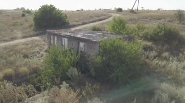 Terk edilmiş ve yol kenarındaki eski tuğla evi yok etmiş. Köyün harabelerine hava manzarası.