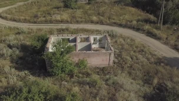 Abandonada e destruída velha casa de tijolos pela estrada. Vista aérea para ruínas da aldeia. — Vídeo de Stock