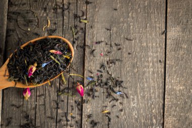 Ahşap Kaplamalar, beyaz zemin üzerine kuru çay. Kırmızı, yeşil ve siyah çay yaprakları. Makro fotoğraf.