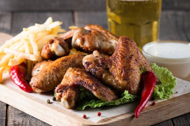 Yakın çekim fotoğraf Barbekü tavuk kanatlı patates ve bira. Barbekü soslar, ketçap, mayonez etli. Hızlı ve abur cubur kavramı. 