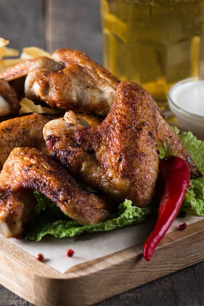 Yakın çekim fotoğraf Barbekü tavuk kanatlı patates ve bira. Barbekü soslar, ketçap, mayonez etli. Hızlı ve abur cubur kavramı. 