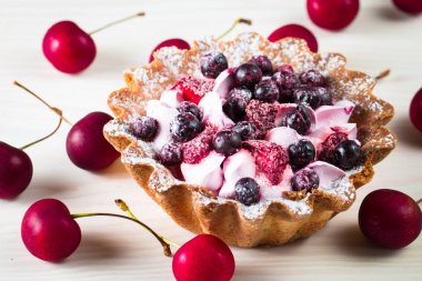 Taze meyve ve meyve ahşap zemin üzerine atmak şekerli tatlı tart. Ahududu, incir, çilek, kiraz ve krema ile lezzetli tatlı pasta.