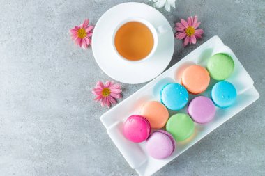 Pasta macarons, hediye kutusu, çay, kahve, cappuccino ve çiçek fotoğrafı. Tatlı romantik gıda acıbadem kurabiyesi kavramı. Sabah kahvaltı ve hediyeler. Sevgililer günü kavramı.