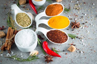 Tahta kaşık içinde baharatlar. Otlar. Köri, safran, zerdeçal, biberiye, tarçın, sarımsak, biber, anason ahşap rustik arka plan üzerinde. Baharatlar ve otlar topluluğu. Tuz, kırmızı biber. Uzay kopyalayın. Üstten görünüm. Afiş. Düz yatıyordu.