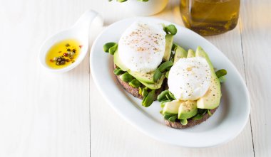 Avokado tost, kiraz domates ahşap arka plan üzerinde. Kahvaltı tost avokado, Vejetaryen gıda, sağlıklı beslenme kavramı ile. Avokado ve haşlanmış yumurta ile sağlıklı sandviç.