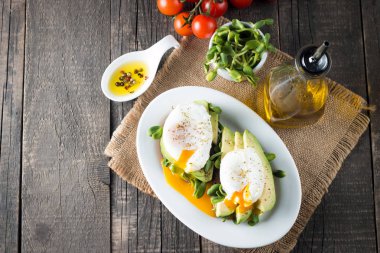 Avokado tost, kiraz domates ahşap arka plan üzerinde. Kahvaltı tost avokado, Vejetaryen gıda, sağlıklı beslenme kavramı ile. Avokado ve haşlanmış yumurta ile sağlıklı sandviç.