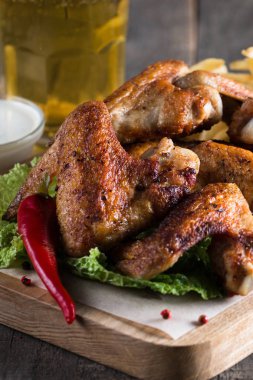 Yakın çekim fotoğraf Barbekü tavuk kanatlı patates ve bira. Barbekü soslar, ketçap, mayonez etli. Hızlı ve abur cubur kavramı. 