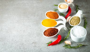 Tahta kaşık içinde baharatlar. Otlar. Köri, safran, zerdeçal, biberiye, tarçın, sarımsak, biber, anason ahşap rustik arka plan üzerinde. Baharatlar ve otlar topluluğu. Tuz, kırmızı biber. Uzay kopyalayın. Üstten görünüm. Afiş. Düz yatıyordu.