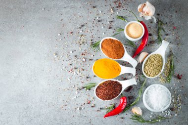 Tahta kaşık içinde baharatlar. Otlar. Köri, safran, zerdeçal, biberiye, tarçın, sarımsak, biber, anason ahşap rustik arka plan üzerinde. Baharatlar ve otlar topluluğu. Tuz, kırmızı biber. Uzay kopyalayın. Üstten görünüm. Afiş. Düz yatıyordu.