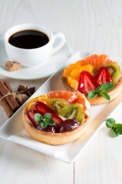 Taze meyve ve meyve ahşap zemin üzerine atmak şekerli tatlı tart. Ahududu, üzüm, çilek, kiraz, kivi, greyfurt ve krema ile lezzetli tatlı pasta.