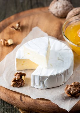 Brie peyniri. Camembert peyniri. Taze Brie peyniri ve tahtadan bir dilim fındık, bal ve yaprakla. İtalyan, Fransız peyniri.