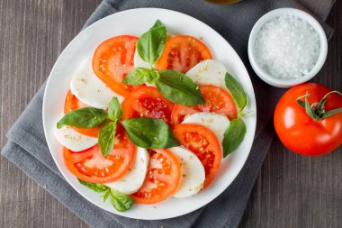 Caprese salatası olgun domates, fesleğen, buffalo mozzarella peyniri ile yakın çekim fotoğraf. İtalyan ve Akdeniz gıda kavramı. Taze ve sağlıklı organik yemek. Starter ve antipasti. 