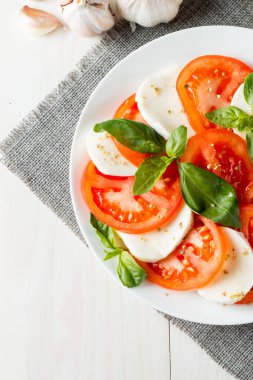 Caprese salatası olgun domates, fesleğen, buffalo mozzarella peyniri ile yakın çekim fotoğraf. İtalyan ve Akdeniz gıda kavramı. Taze ve sağlıklı organik yemek. Starter ve antipasti. 