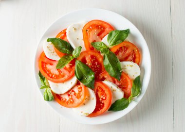 Caprese salatası olgun domates, fesleğen, buffalo mozzarella peyniri ile yakın çekim fotoğraf. İtalyan ve Akdeniz gıda kavramı. Taze ve sağlıklı organik yemek. Starter ve antipasti. 