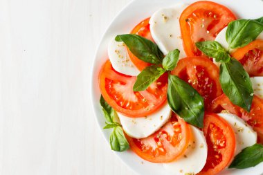 Caprese salatası olgun domates, fesleğen, buffalo mozzarella peyniri ile yakın çekim fotoğraf. İtalyan ve Akdeniz gıda kavramı. Taze ve sağlıklı organik yemek. Starter ve antipasti. 