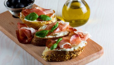 İtalyan domates, jambon, jamon, jambon ve peynir bruschetta. Tapas, antipasti Doğranmış sebzeler, otlar ve petrol ızgara ciabatta ve baget ekmek.