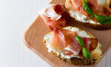 İtalyan domates, jambon, jamon, jambon ve peynir bruschetta. Tapas, antipasti Doğranmış sebzeler, otlar ve petrol ızgara ciabatta ve baget ekmek.