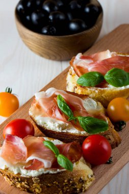 İtalyan domates, jambon, jamon, jambon ve peynir bruschetta. Tapas, antipasti Doğranmış sebzeler, otlar ve petrol ızgara ciabatta ve baget ekmek.