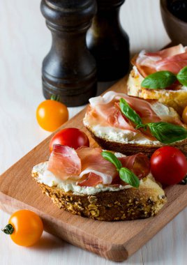 İtalyan domates, jambon, jamon, jambon ve peynir bruschetta. Tapas, antipasti Doğranmış sebzeler, otlar ve petrol ızgara ciabatta ve baget ekmek.