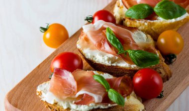 İtalyan domates, jambon, jamon, jambon ve peynir bruschetta. Tapas, antipasti Doğranmış sebzeler, otlar ve petrol ızgara ciabatta ve baget ekmek.