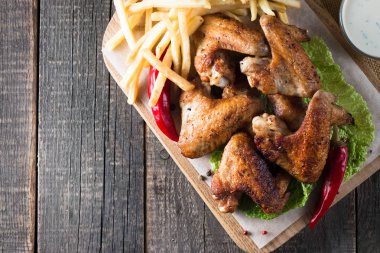 Yakın çekim fotoğraf Barbekü tavuk kanatlı patates ve bira. Barbekü soslar, ketçap, mayonez etli. Hızlı ve abur cubur kavramı. 