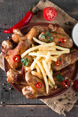 Yakın çekim fotoğraf Barbekü tavuk kanatlı patates ve bira. Barbekü soslar, ketçap, mayonez etli. Hızlı ve abur cubur kavramı. 