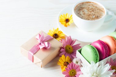 Pasta macarons, hediye kutusu, çay, kahve, cappuccino ve çiçek fotoğrafı. Tatlı romantik gıda acıbadem kurabiyesi kavramı. Sabah kahvaltı ve hediyeler. Sevgililer günü kavramı.