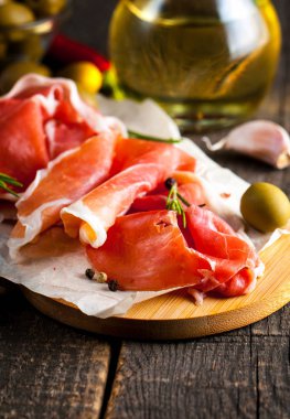 prosciutto ile karışık zeytin ve ahşap kesme tahtası üzerinde kırmızı biber ince dilim closeup